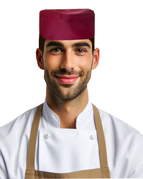 Adjustable chef skull cap in burgundy worn by smiling chef in white uniform, perfect for professional kitchens.